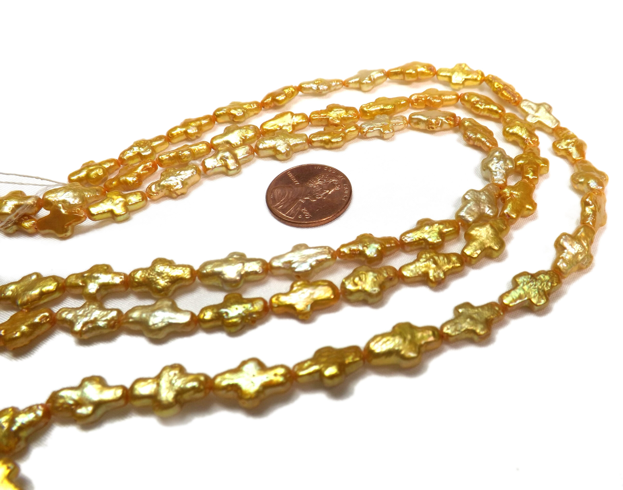 Gold colored cross shaped pearls on loose strands